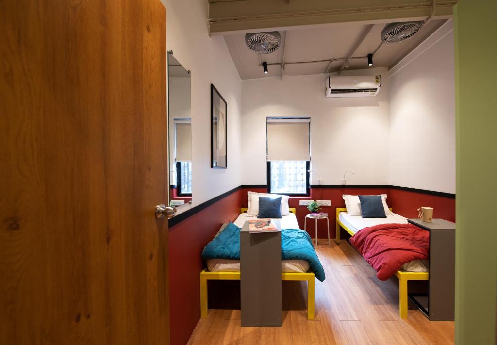a room with two beds and a table in it at THE BAUHAUS in Mumbai