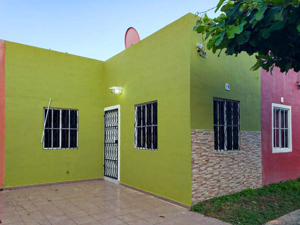 ein grünes Gebäude mit schwarzen Fenstern darauf in der Unterkunft Jasper House en Ciudad Real Santa Ana in Santa Ana