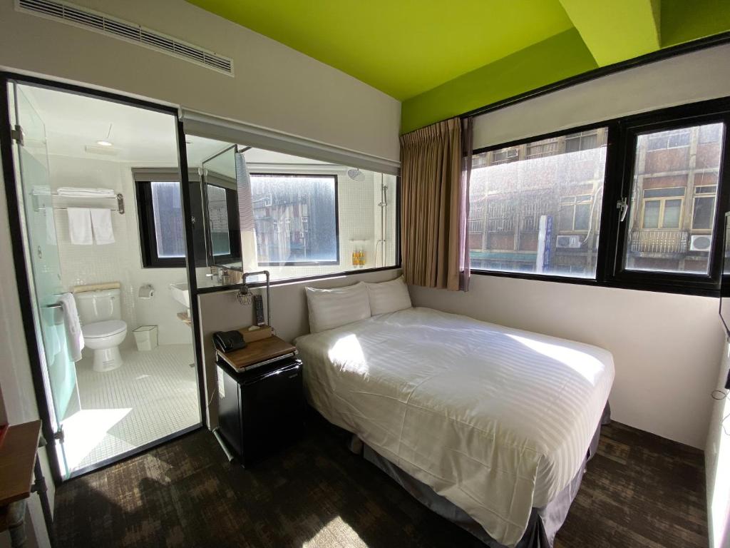 a bedroom with a bed and a bathroom with a shower at Cho Hotel in Taipei