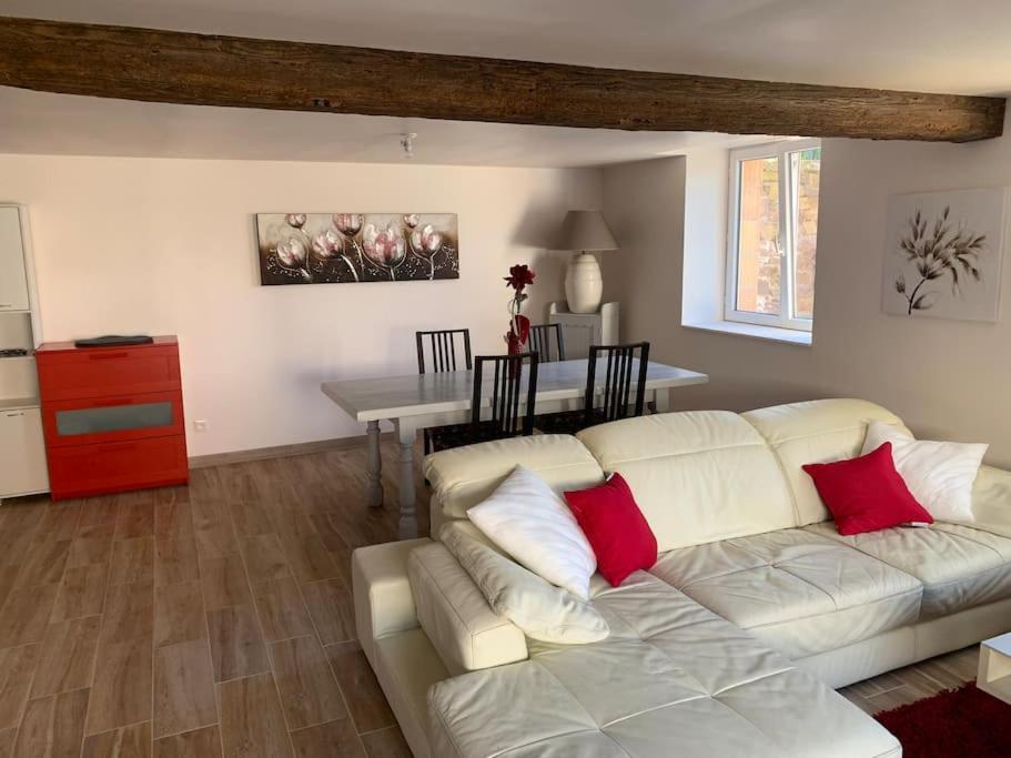 uma sala de estar com um sofá branco com almofadas vermelhas em T3 neuf - maison alsacienne au calme avec cour privée em Dachstein