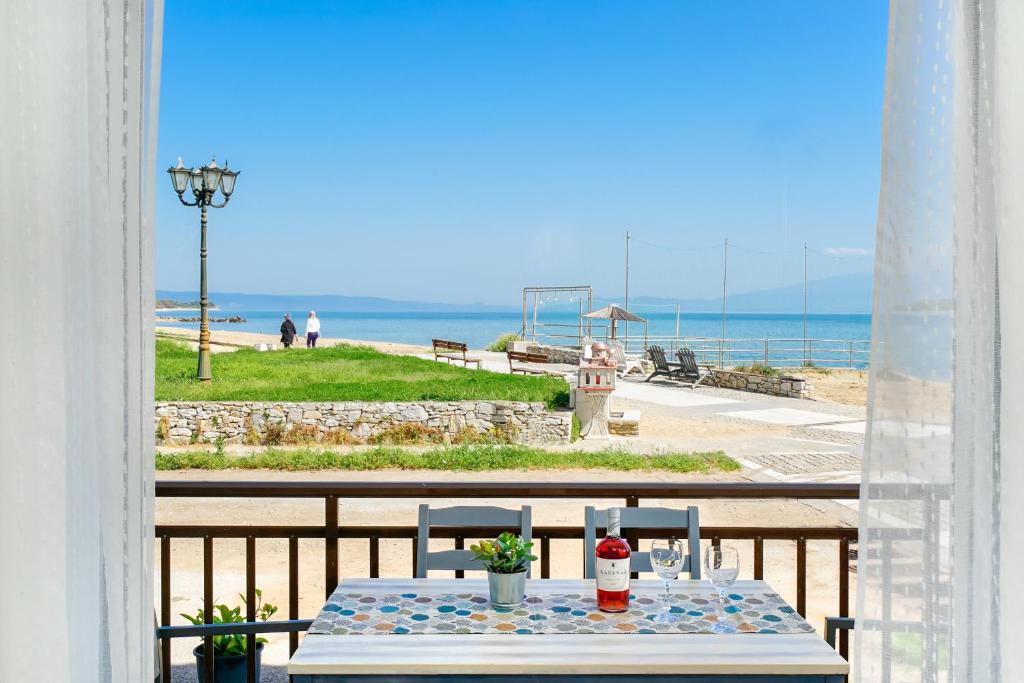 - une table sur un balcon avec vue sur l'océan dans l'établissement Evelyn Studios, à Olympiada