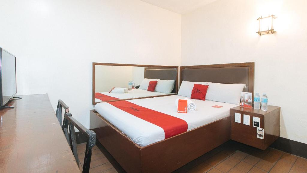 RedDoorz @ Riches Holiday Hotel Avenida في مانيلا: غرفة نوم بسرير كبير في غرفة