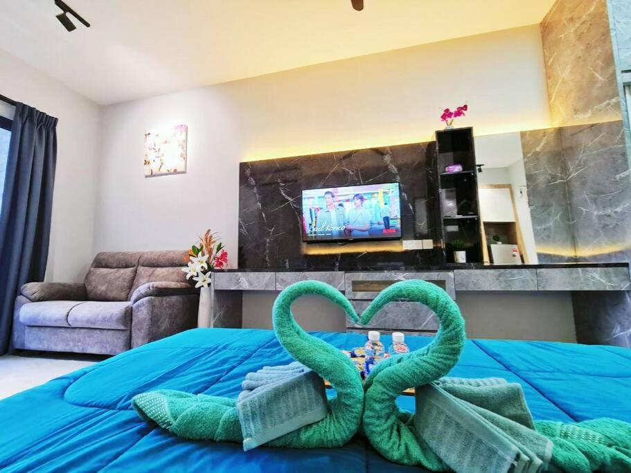 two towels in the shape of hearts on a bed at LovelySuite#RelaxChill#Netflix#PrivateBathtub#FreeParking#PoolView#ImperioResidence#LuxuryCondo in Melaka