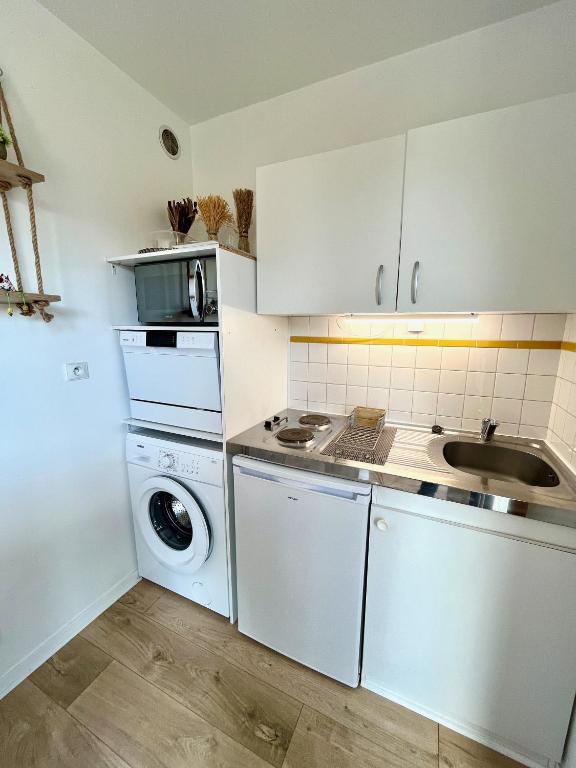 a kitchen with a washing machine and a sink at Salm YourHostHelper in Ouistreham