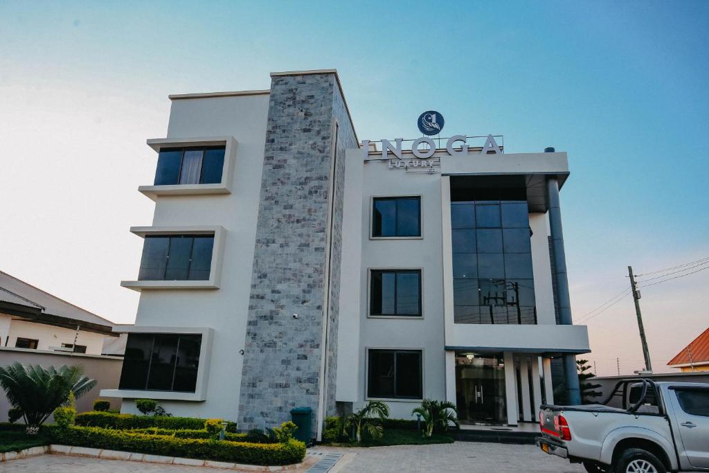 a building with a truck parked in front of it at Inoga Luxury Hotel in Dodoma