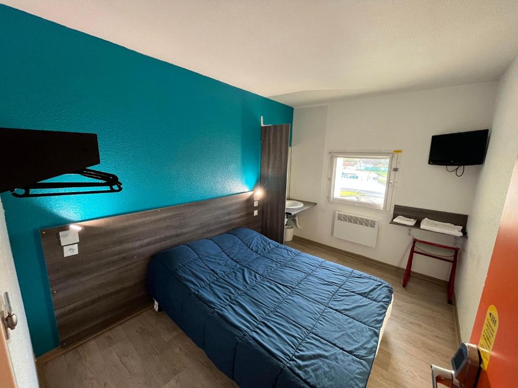 Cette chambre comprend un lit et un mur bleu. dans l'établissement Hotel Eco Blois, à Vineuil
