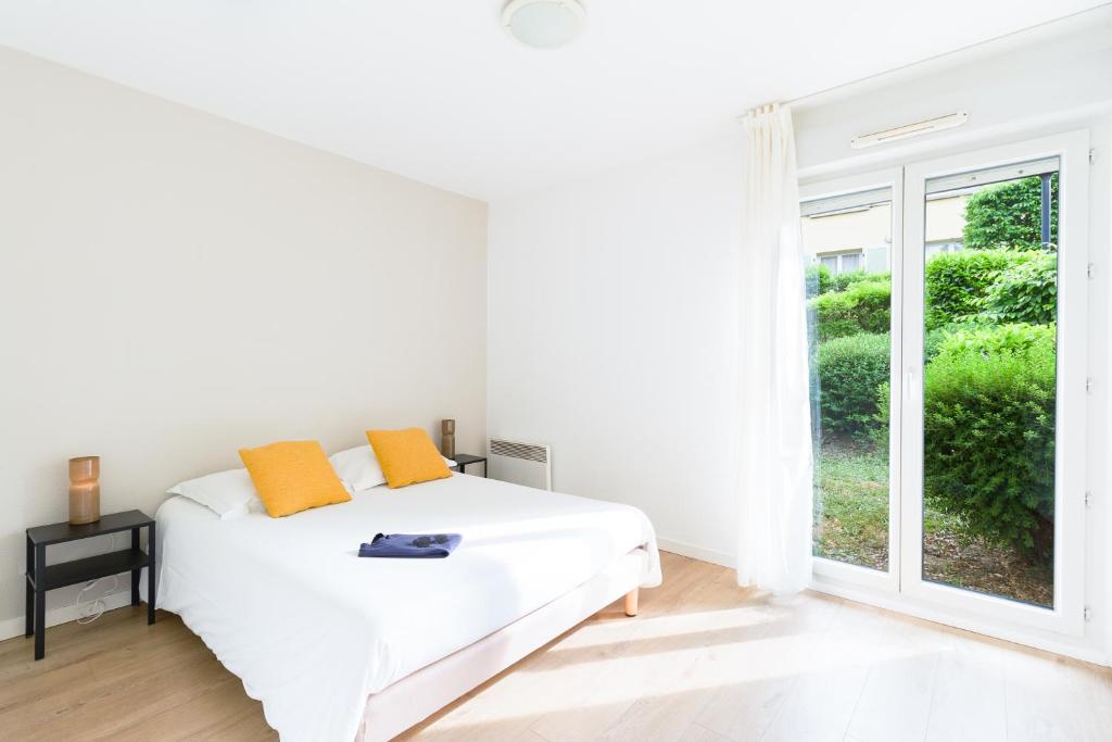 a white bedroom with a bed and a window at Garden & City Lyon - Lissieu in Lissieu