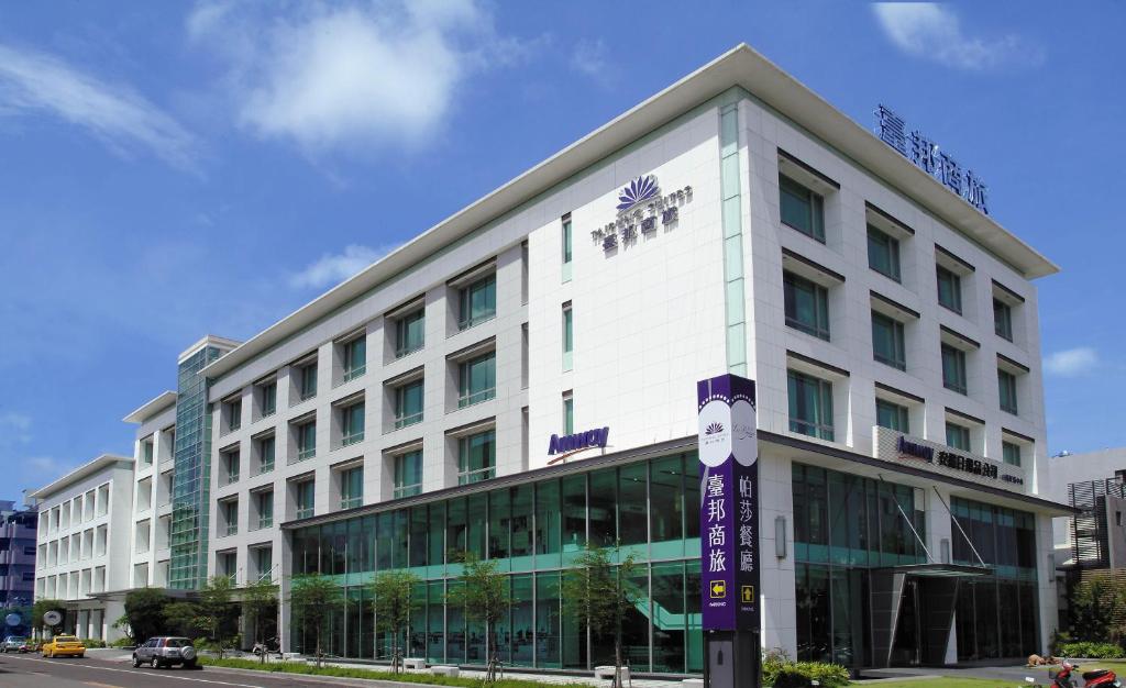 a large white building with a sign in front of it at Taipung Suites in Anping