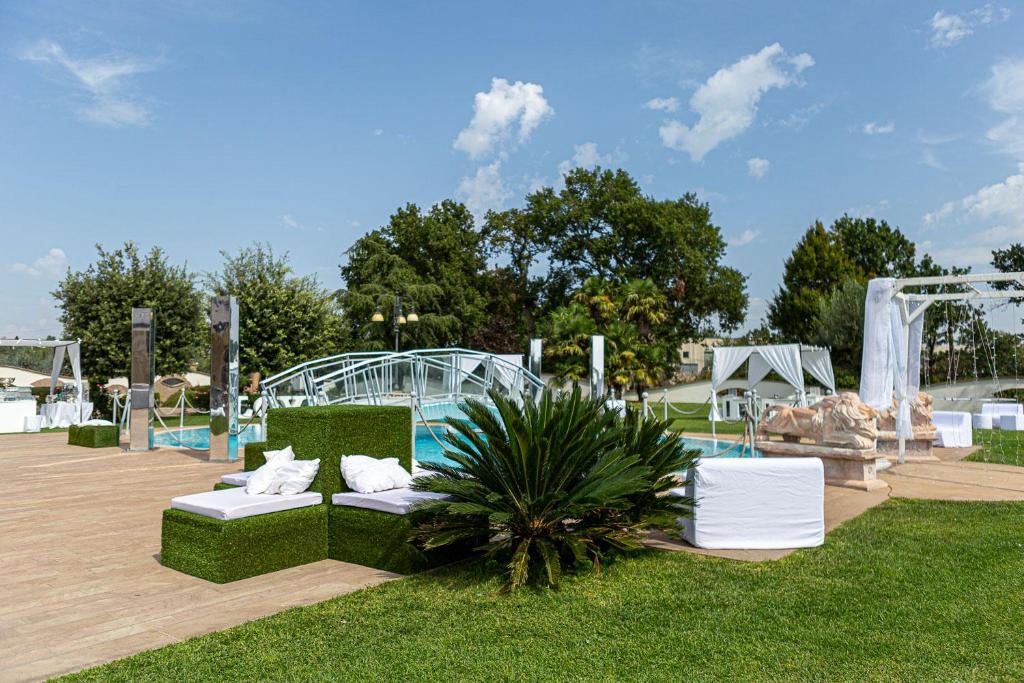 a park with white furniture and a pool at Hotel Villa Sofia in Viterbo