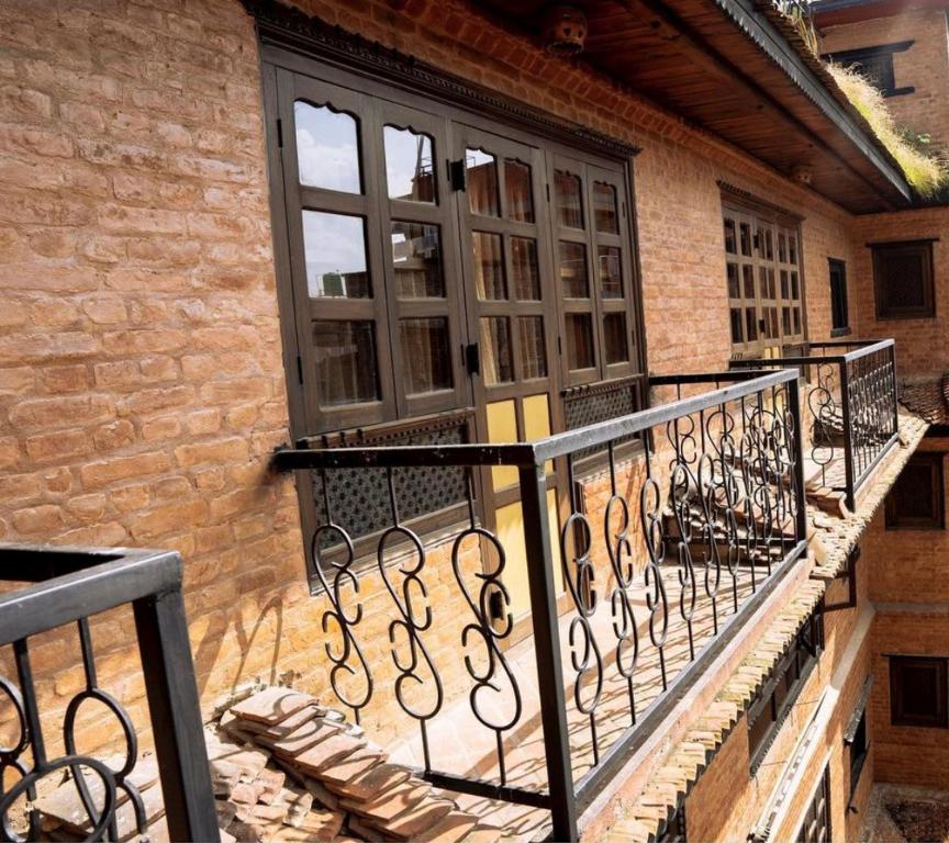 d'un balcon avec une porte noire et une fenêtre. dans l'établissement Shiva Guest House 2, à Bhaktapur