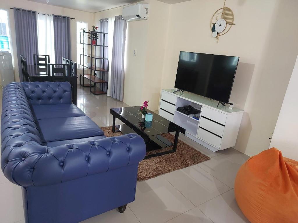 ein Wohnzimmer mit einem blauen Sofa und einem TV in der Unterkunft 3 bed 3 bath Friendly, Friendship area, Fibre bdb in Angeles