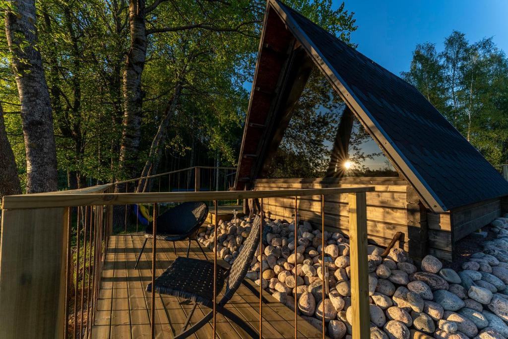 a deck with a cabin with a bunch of logs at Laawu Kultainkoski in Kotka