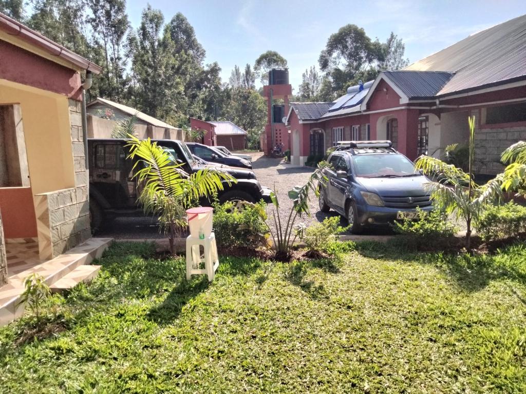 un cortile con auto parcheggiate di fronte a una casa di Good Morning Hotel Rongo a Paulo