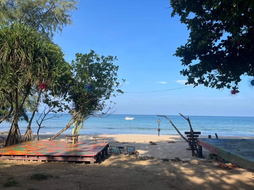 a beach with a building and trees and the ocean at Sanctuary Lanta in Ko Lanta