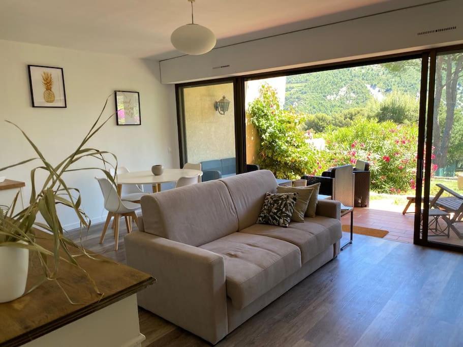 un salon avec un canapé et une table dans l'établissement Le Corton - 45m2 - Parking - Jardin - Wifi, à Cassis