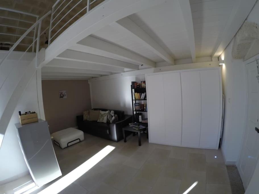 salon z kanapą i białym sufitem w obiekcie La dolce casa - Puglia last minute w mieście Carovigno