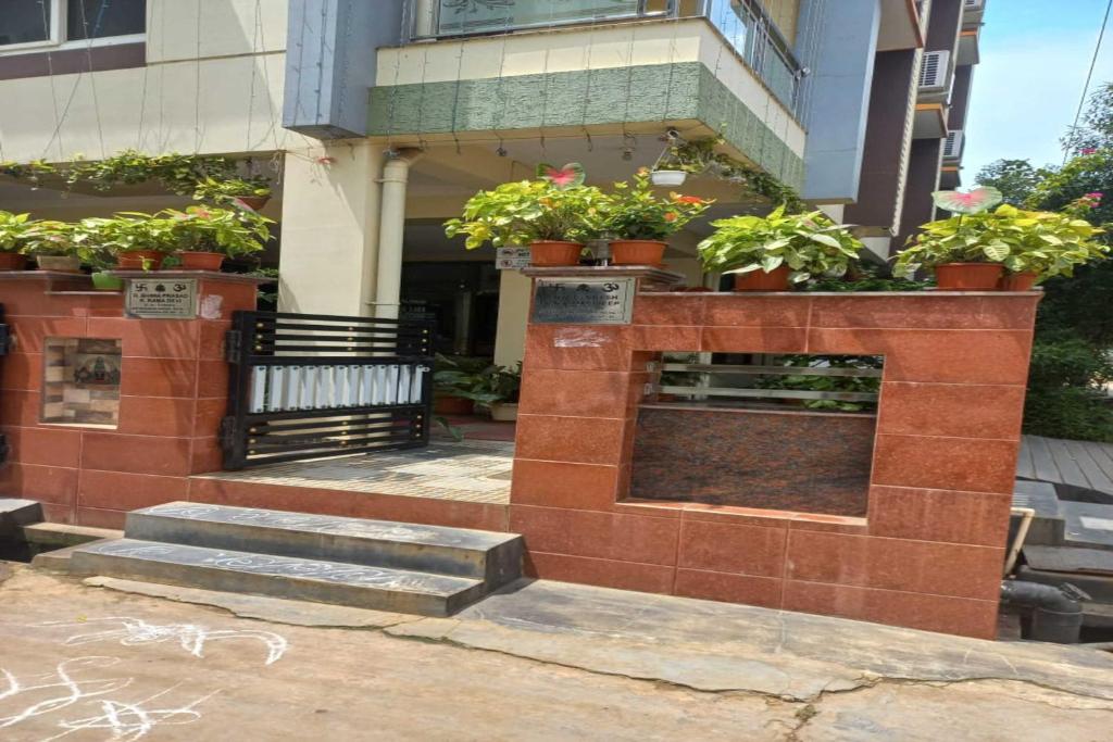 a brick fireplace with potted plants on a building at Bhimas Residency in Kurmannapalem