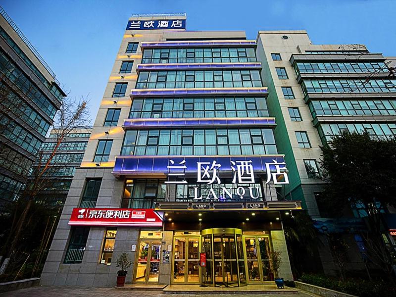 un grand bâtiment avec un panneau devant lui dans l'établissement LanOu Hotel Zhengzhou High-Tech Zone Headquarter Enterprise Base, à Zhengzhou