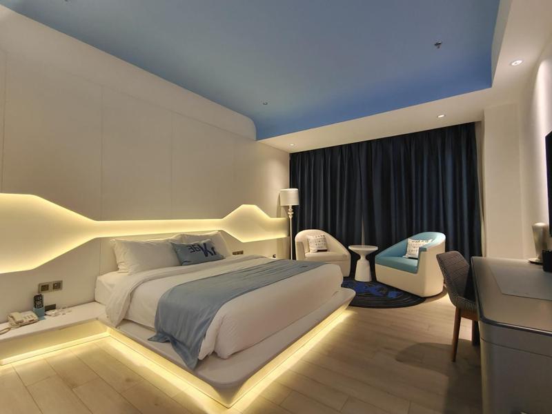 1 dormitorio con 1 cama blanca grande y escritorio en LanOu Hotel Bazhou Korla Jindu Plaza, en Korla