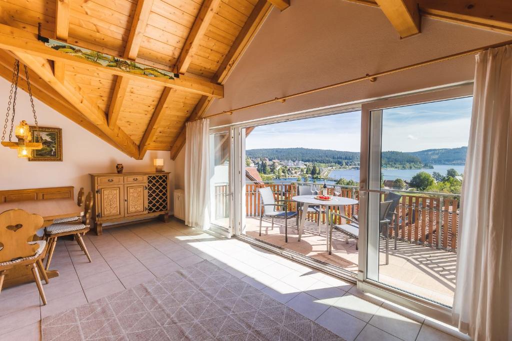 a room with a balcony with a table and chairs at Ferienwohnung Seeglück mit großzügigem Südbalkon und herrlichem Seeblick in Schluchsee