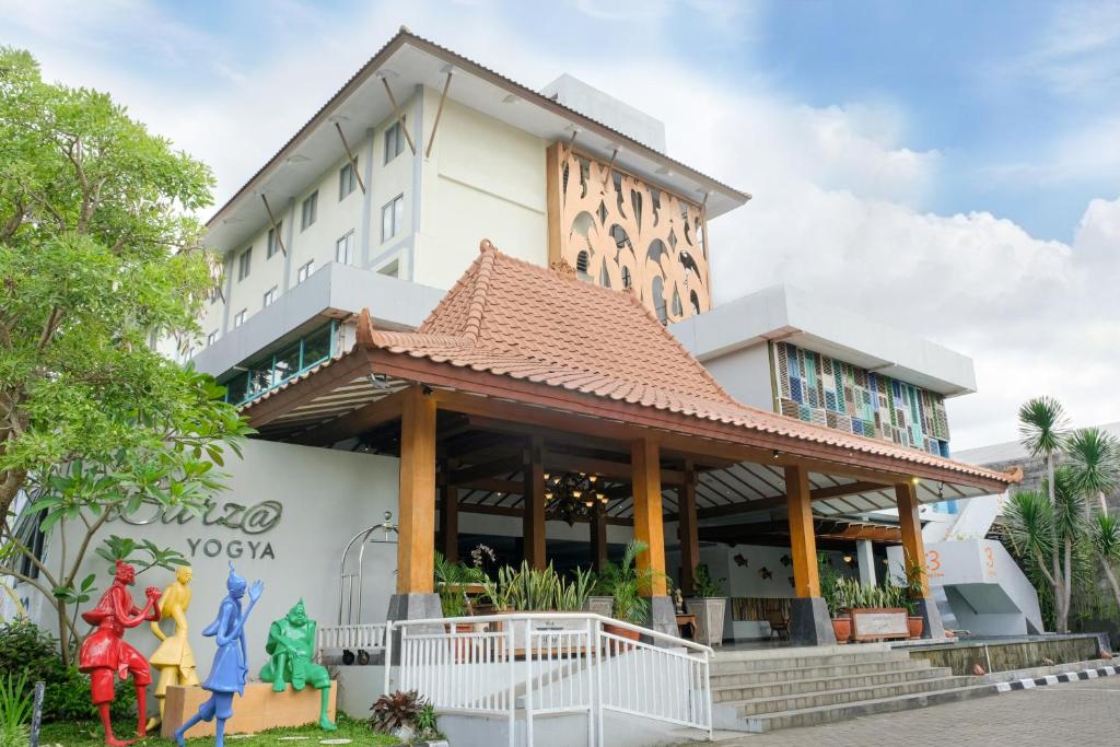 un edificio con estatuas delante de él en Burza Hotel Yogyakarta en Yogyakarta