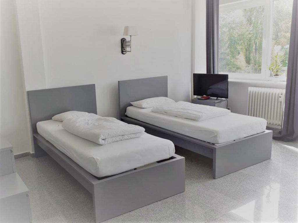 Dos camas individuales en una habitación con ventana. en Mehrbett-Apartment 5 Citynah, einfache Ausstattung, en Hamburgo