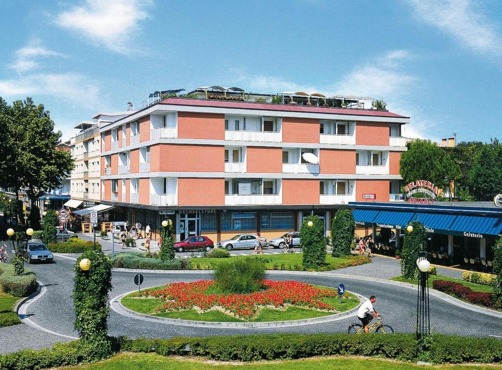 a man riding a bike in front of a building at Appartamenti Foyer in Bibione