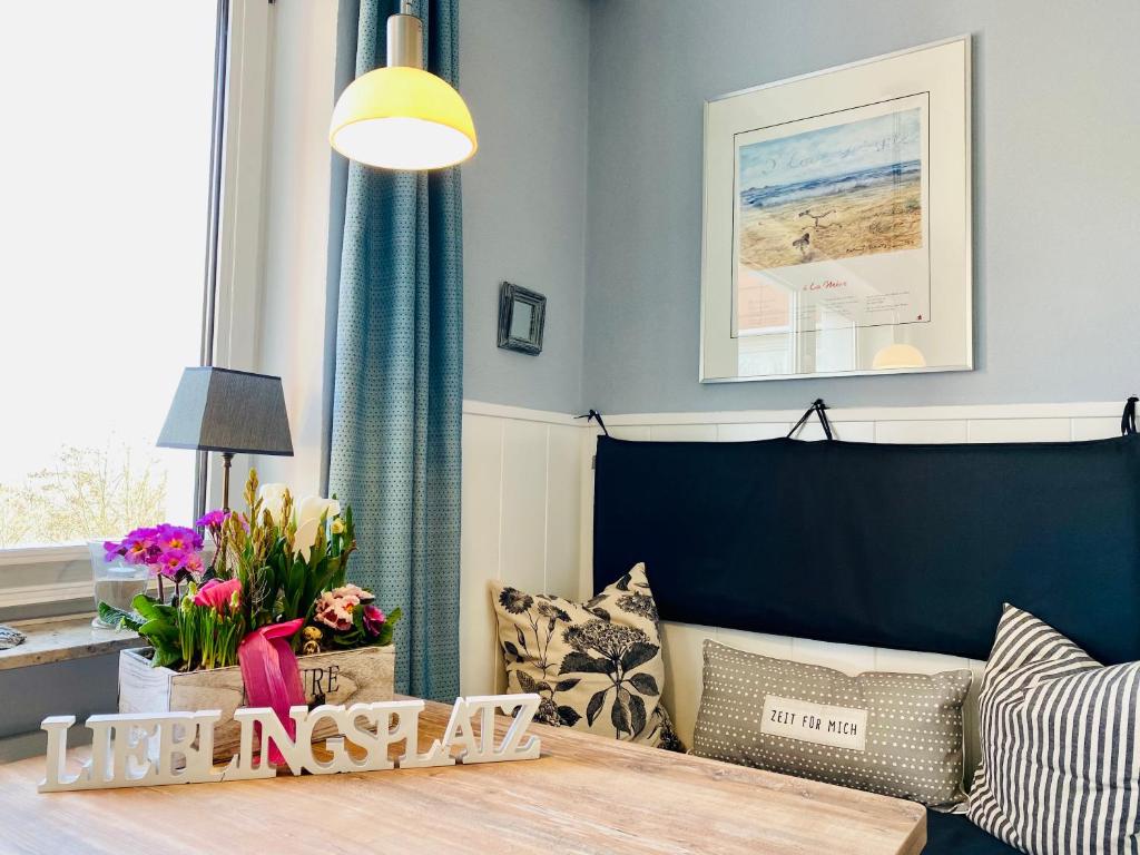 een slaapkamer met een bed en een tafel met bloemen bij Mein Lieblingsplatz (App.21) in Sankt Peter-Ording