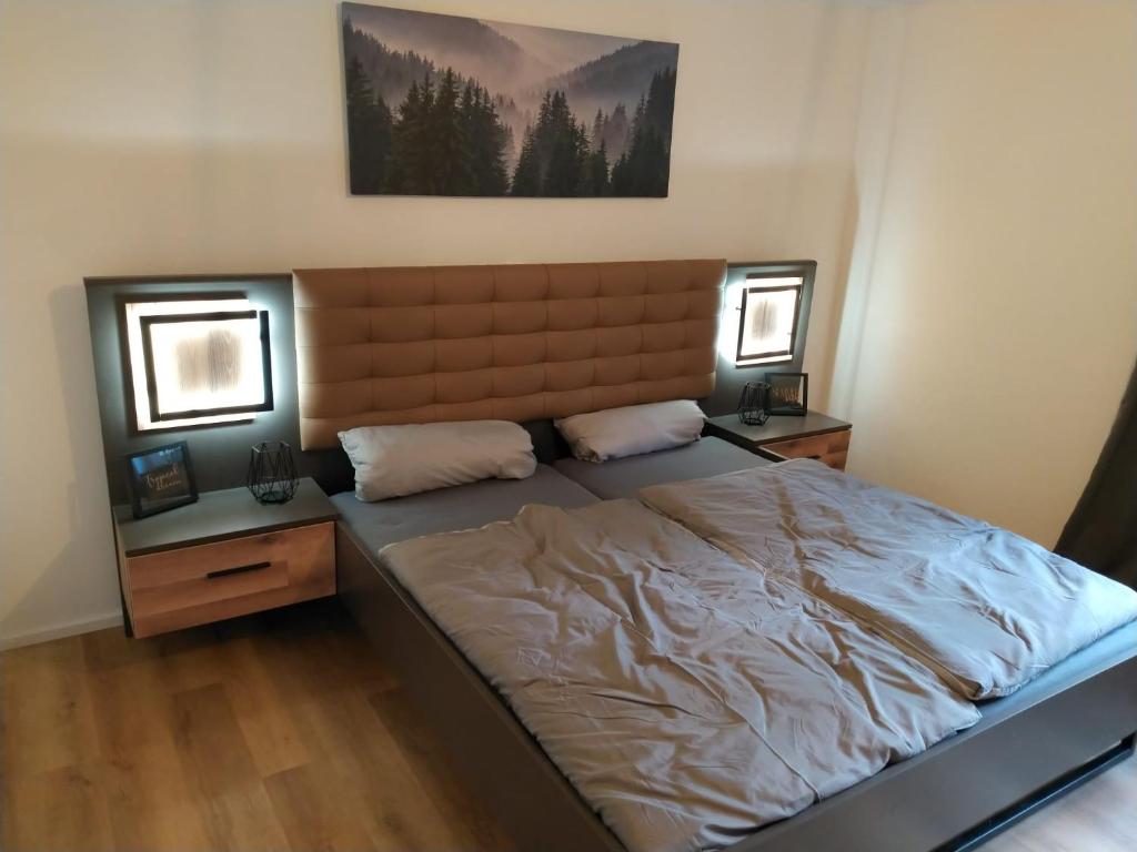 ein Schlafzimmer mit einem großen Bett und zwei Nachttischen in der Unterkunft Ferienwohnung Maustadt in Memmingen