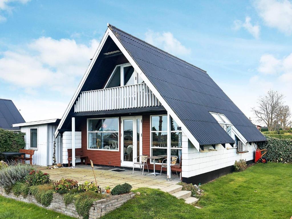 una pequeña casa con paneles solares en el techo en 6 person holiday home in Bogense en Bogense