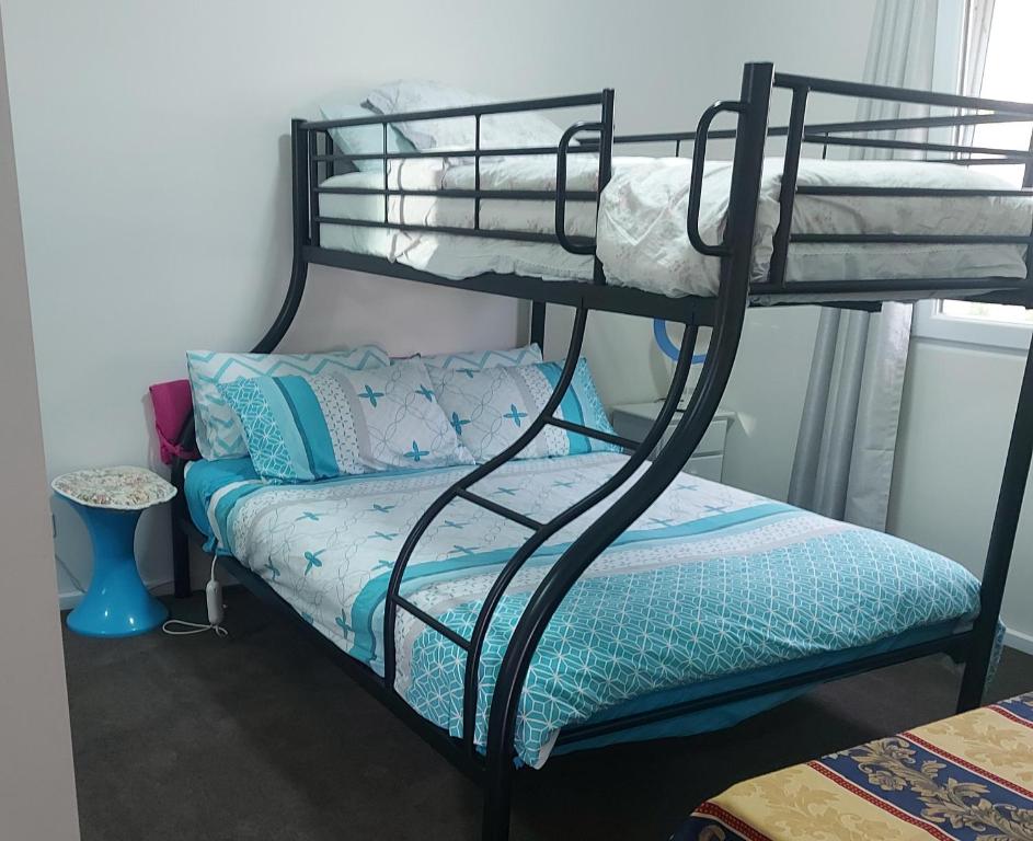 a bedroom with two bunk beds and a couch at Cascabelbnb Private 2BR apartment in Noarlunga