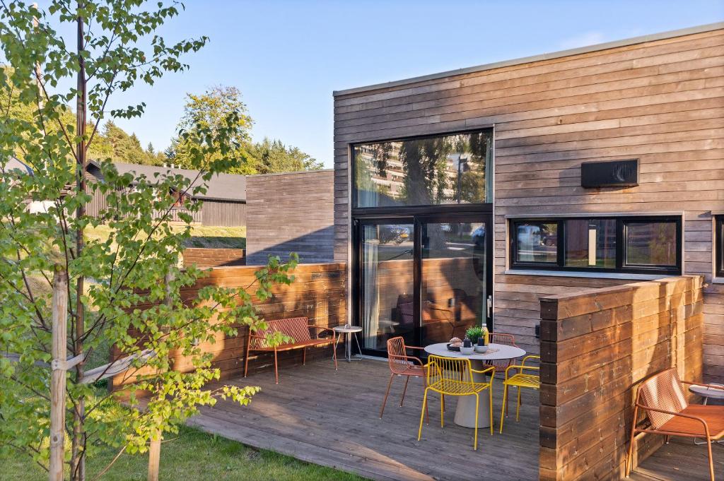 una terraza de madera con mesa y sillas en Topcamp Bogstad - Oslo en Oslo