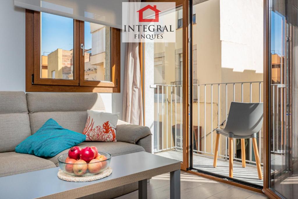 a living room with a couch and a table with fruit on it at Palamós Exclusive Apartments in Palamós