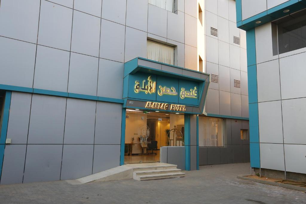 فندق حصن الأبلق - Alablaq Hotel في تيماء: محل امام مبنى عليه لافته