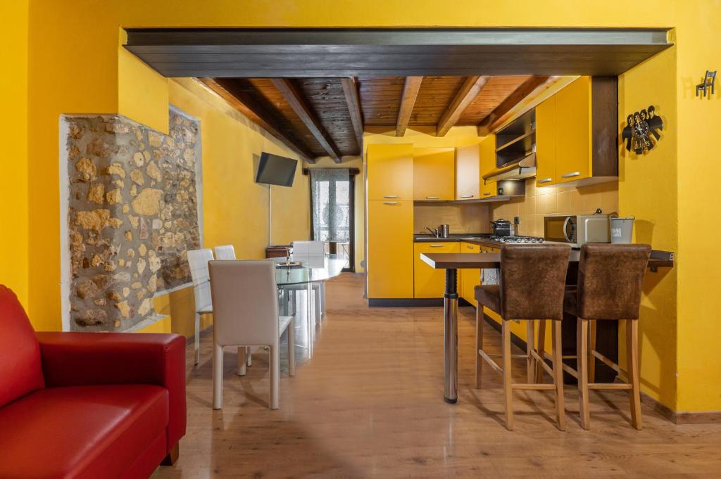 een keuken met gele muren en een tafel en stoelen bij Stylish 2 bedroom with balcony in Verona