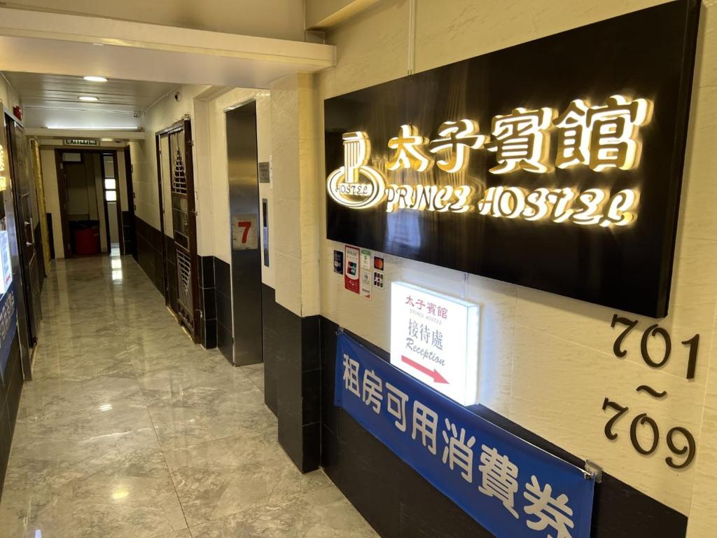 a hallway in a building with a sign on the wall at Prince Hotel in Hong Kong