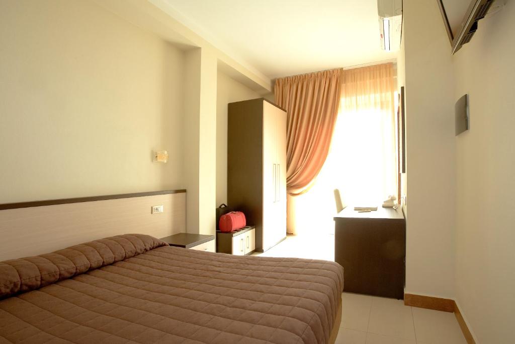 a hotel room with a bed and a window at Hotel Spinelli in Viareggio