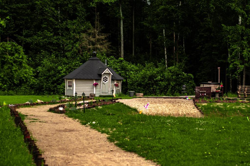 mały domek na środku żwirowej drogi w obiekcie Anielski Zakątek w mieście Kolonia Rybacka