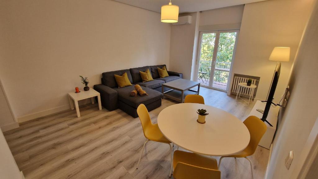 salon z kanapą i stołem w obiekcie Espectacular apartamento en Cuzco / Alberto Alcocer w Madrycie
