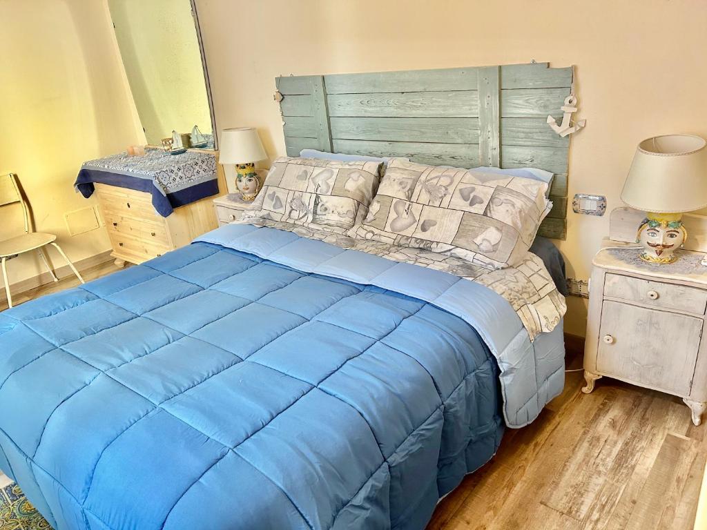 a bedroom with a blue bed with a wooden headboard at Casa Filemone in Syracuse