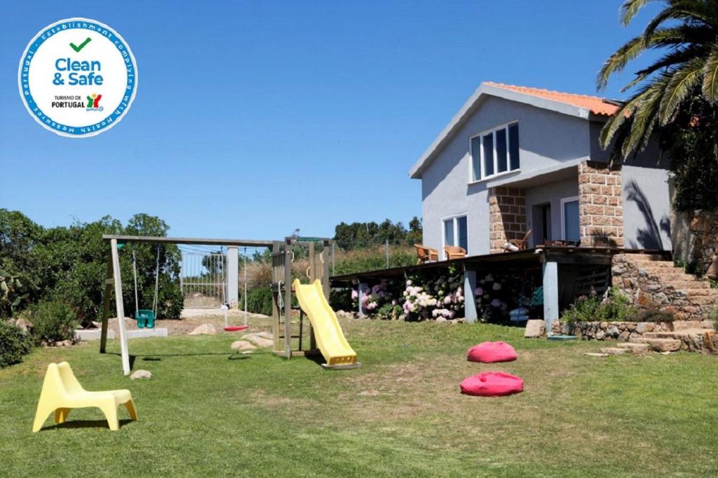 a yard with playground equipment in front of a house at Mira Guincho house with sea view and garden, Cascais in Alcabideche