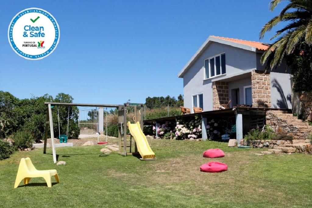 un cortile con parco giochi di fronte a una casa di Mira Guincho house with sea view and garden, Cascais a Alcabideche