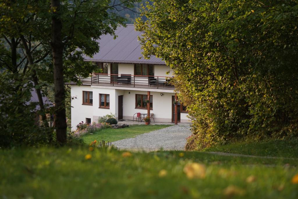 Casa blanca con porche y entrada en Dom przy lesie en Zawadka