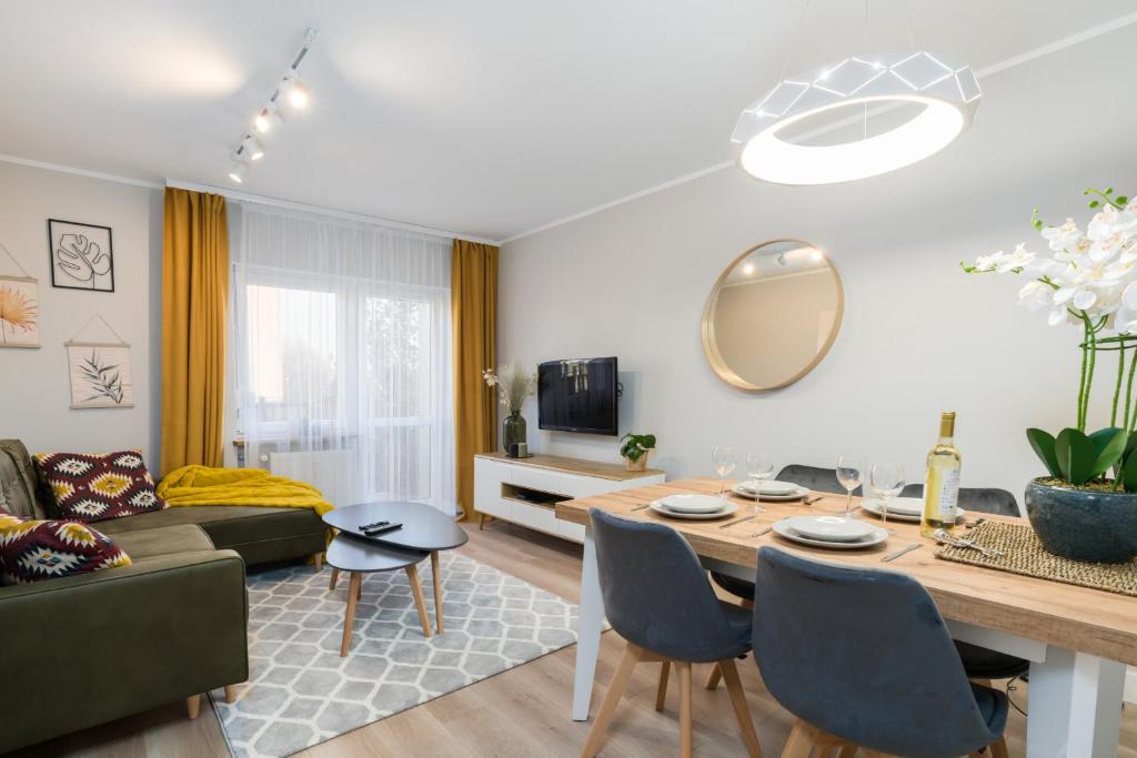 a living room with a table and a couch at Nad Potokiem Apartment Poznań by Renters in Poznań