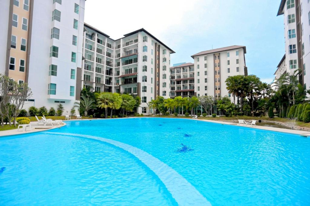 una gran piscina frente a algunos edificios en Le Breeze Resort Hua hin en Cha Am