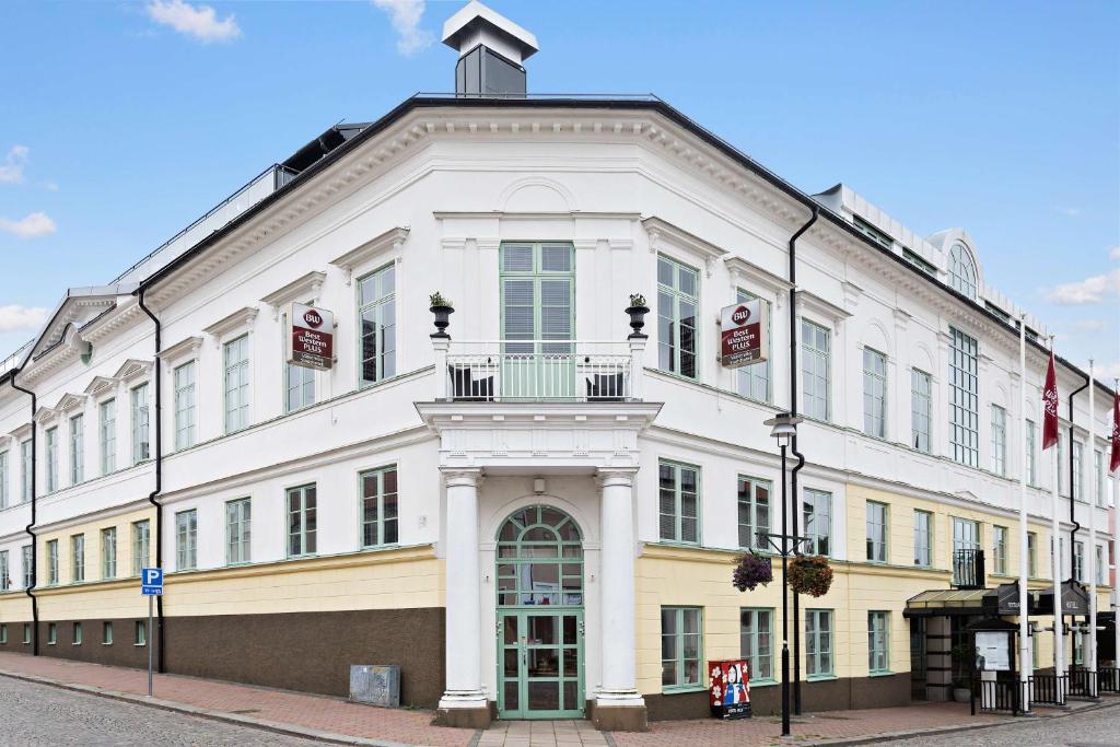 duży biały budynek na rogu ulicy w obiekcie Best Western Plus Västerviks Stadshotell w mieście Västervik