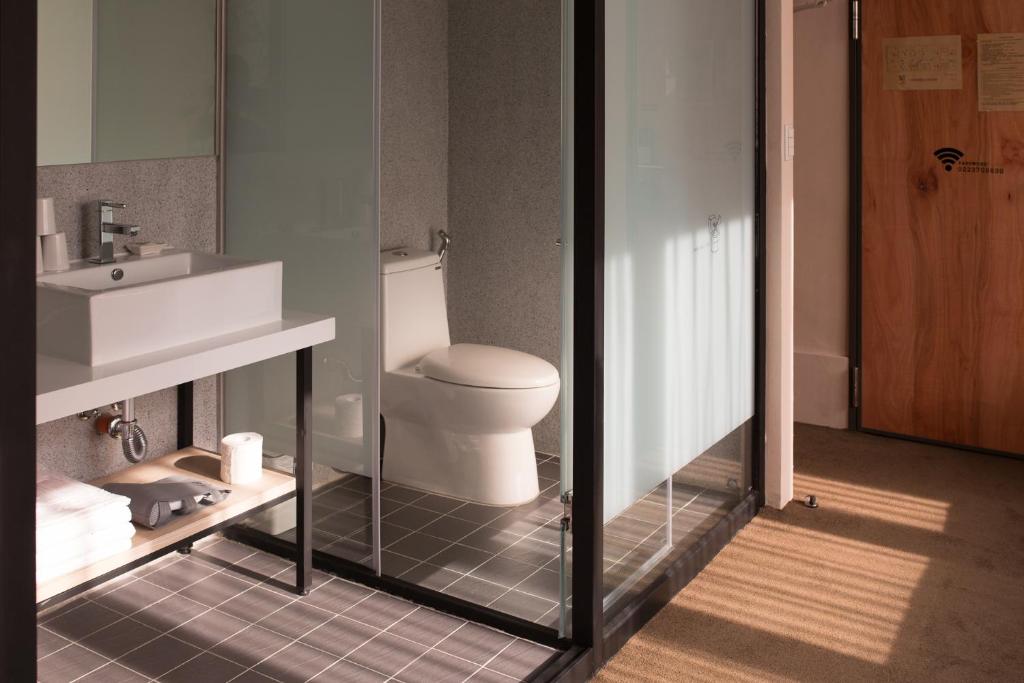 a bathroom with a white toilet and a sink at Cho Hotel in Taipei