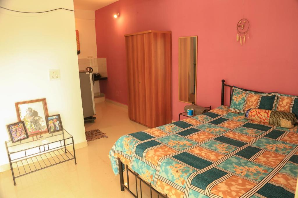 a bedroom with a large bed and a red wall at Dreamcatcher House & Hostel at Arambol Beach in Arambol