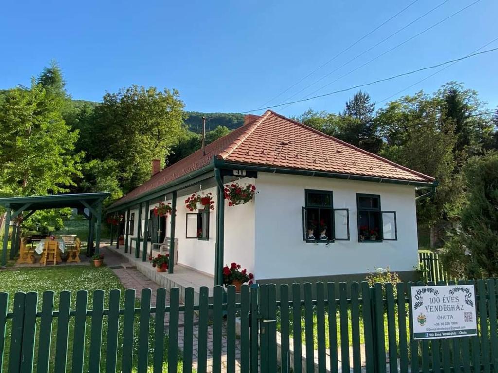 una casa blanca con una valla delante en 100 Éves Vendégház - Háromhuta en Háromhuta