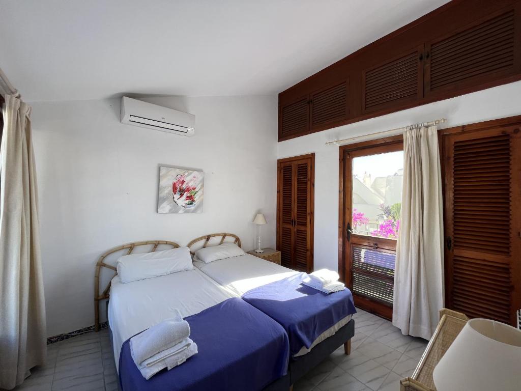 エステポナにあるVillacana 2310のベッドルーム1室(青いシーツと窓付)